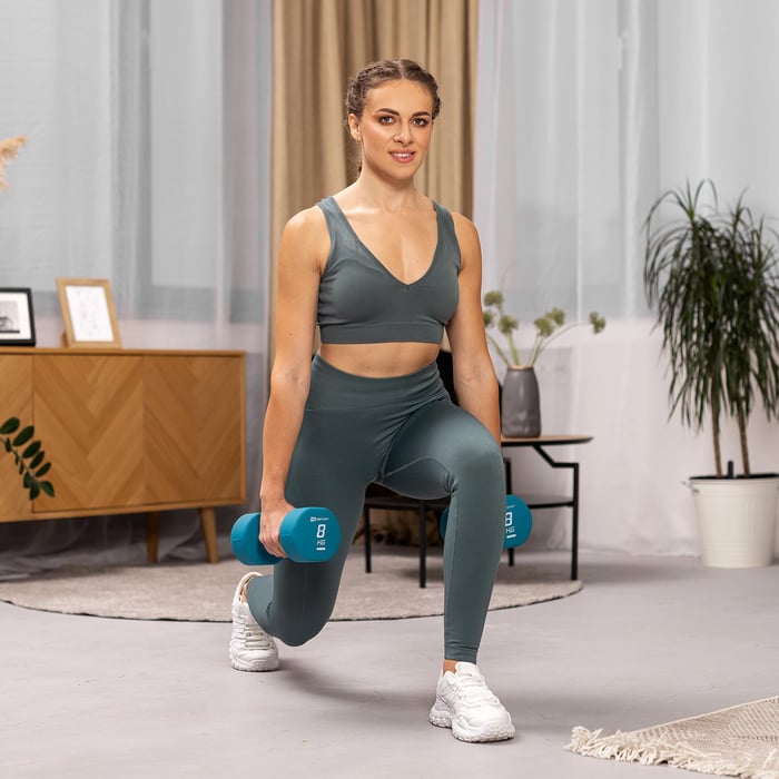 Vrouw doet lunges met blauwe 8 kg neopreen halters
