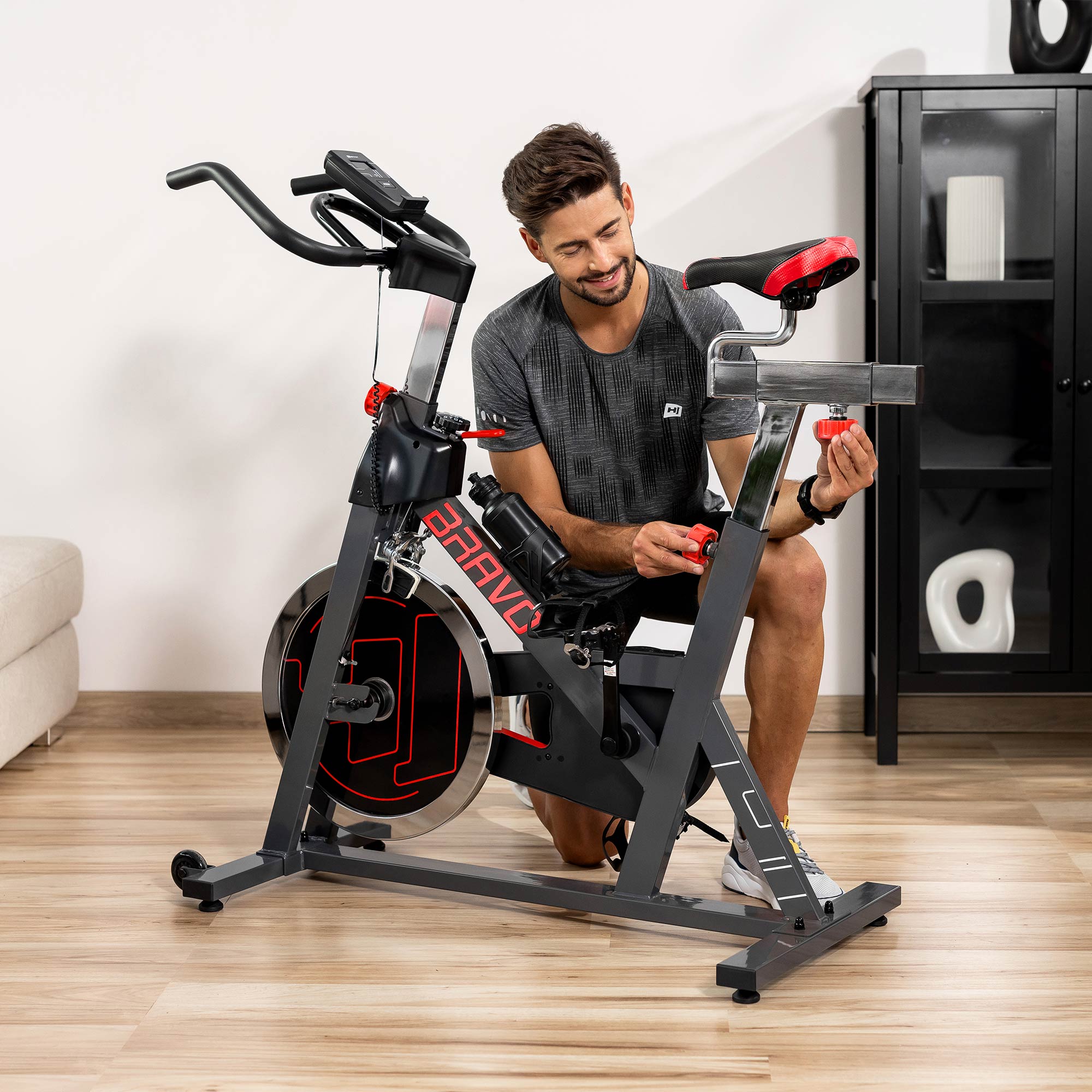 Man stelt het zadel van de Indoor Bike HS-045IC Bravo handmatig af 