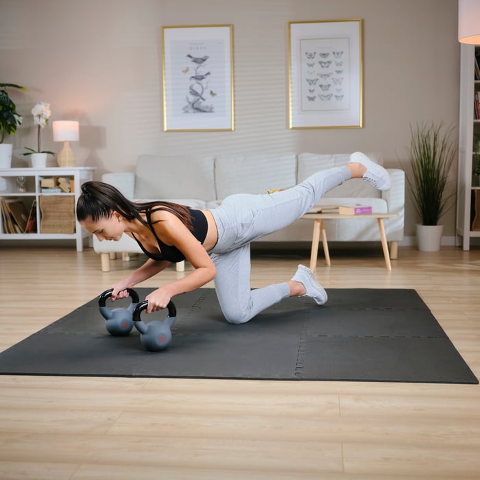 Vrouw traint met twee 8 kg Hop-Sport kettlebells
