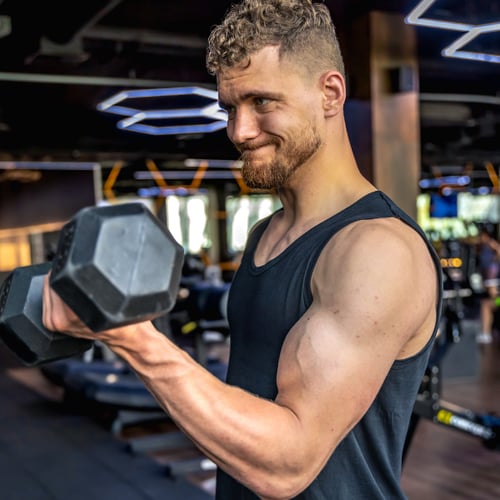 Een man houdt dumbbells vast