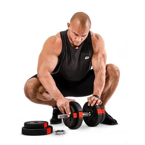 borstoefeningen met dumbbells: gespierde man met pet zit op een bank met twee dumbbells vast