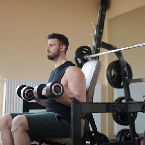 man traint met gewicht