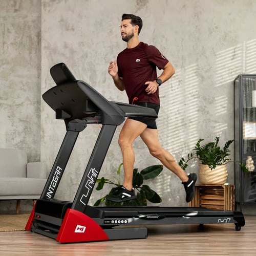 een man rent op een Hop-Sport-loopband in de woonkamer
