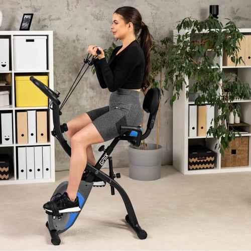 vrouw traint op een hometrainer met rugleuning in een lichte ruimte