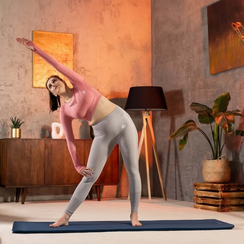 Vrouw doet cooling-down-oefeningen met een zijwaartse buiging op een yogamat