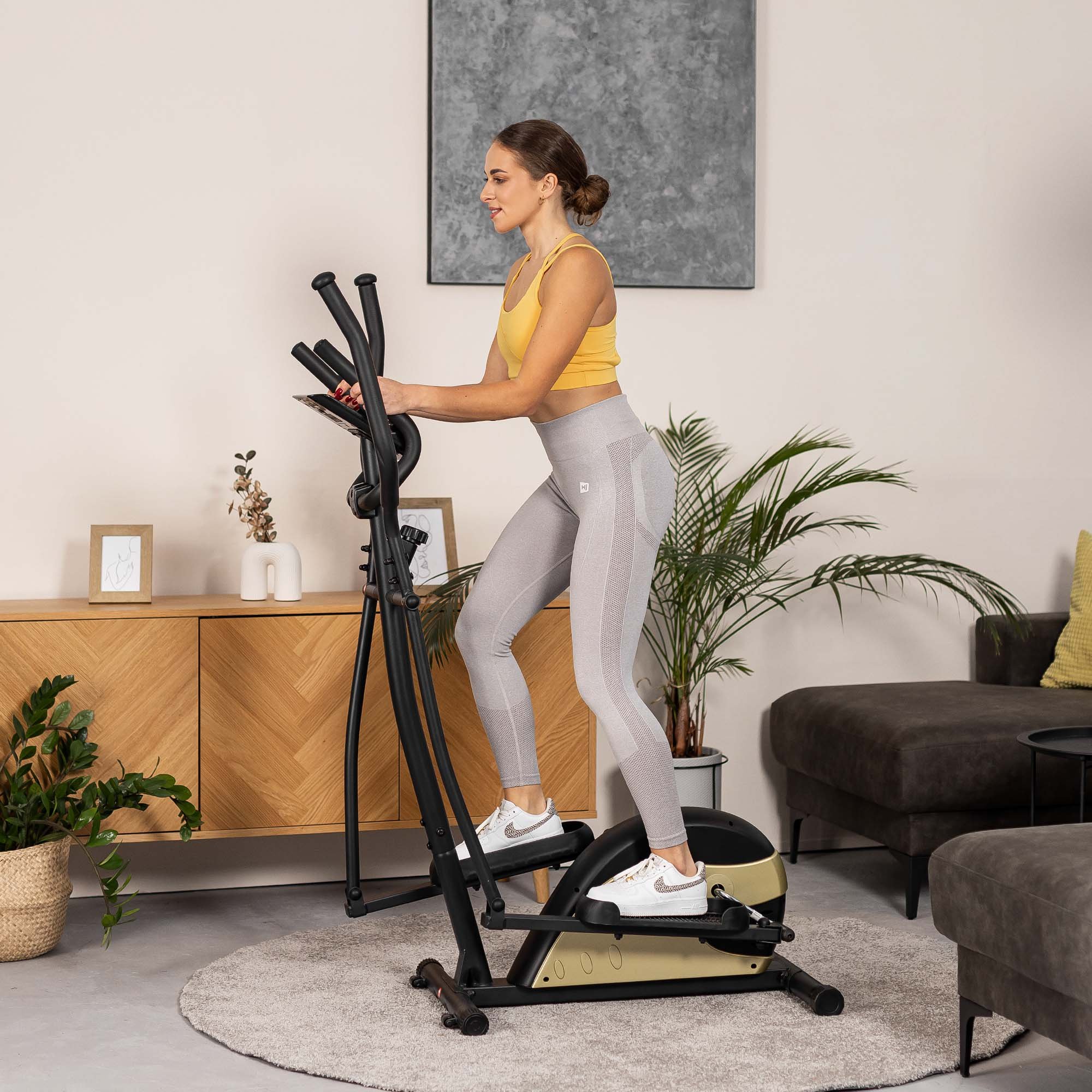 Gebruiker meet hartslag via sensoren op crosstrainer tijdens training