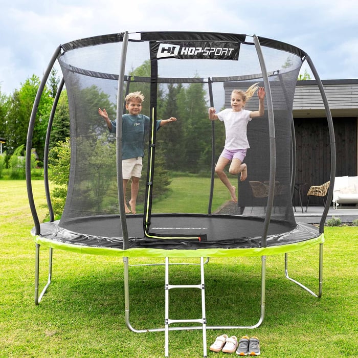Kinderen springen op Hop-Sport trampoline met net in de tuin