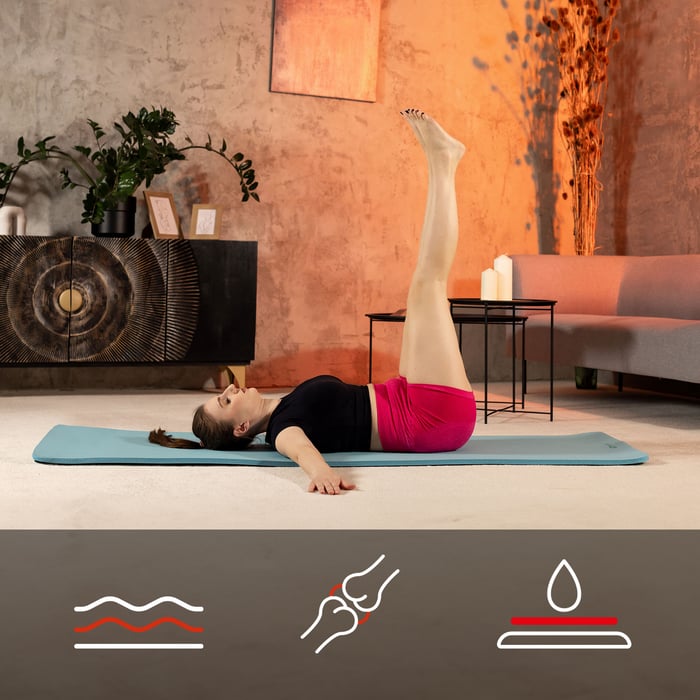 Vrouw voert beenheffing uit op blauwe NBR-fitnessmat van Hop-Sport
